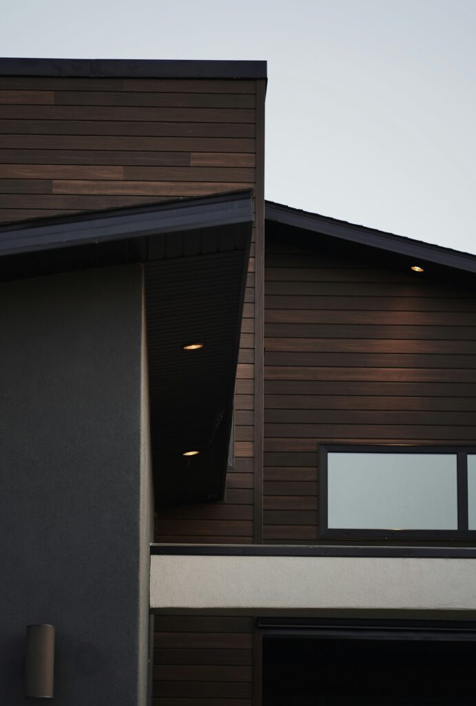 | Dynamic Design Solutions, LLC Cost to build a house 2026 modern custom home exterior with wood siding and contemporary design