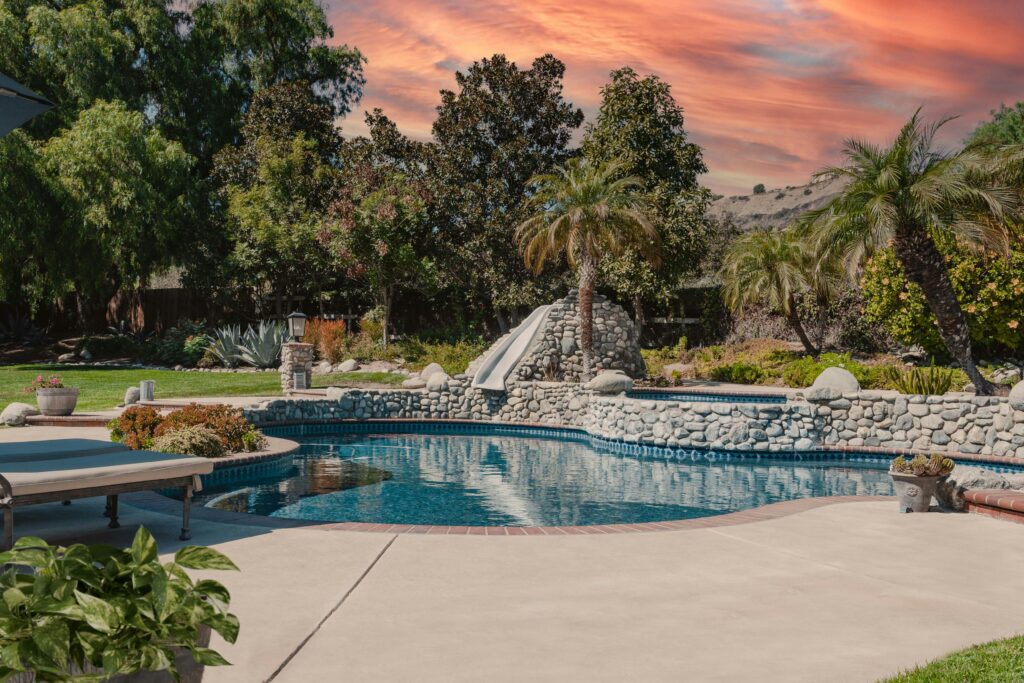 Outdoor kitchen and pool cost 2026 luxury inground swimming pool with fountain landscaping and scenic view